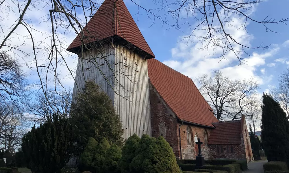 Der hölzerne Turm der Dorfkirche von Rethwisch (Börgerende) wurde bereits von der Stiftung KiBa gefördert. Nur wenige Kilometer weiter liegt der Ostseestrand.