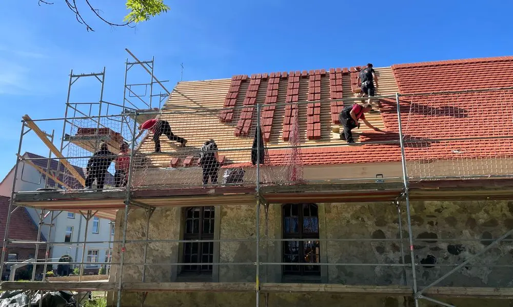 Teamarbeit: das Dach der Dorfkirche wird neu eingedeckt