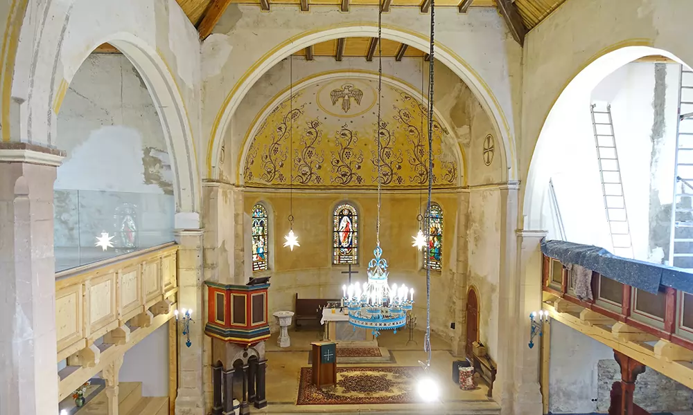 Ansicht von der Westempore: der Chorraum mit dem historischen Leuchter über dem Kirchenschiff